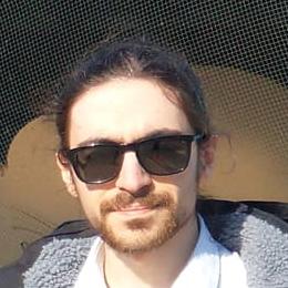 Casual headshot of myself. I am outside in the sun, enjoying myself and smiling :)